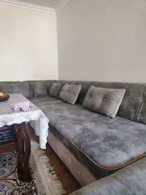Yangi holatdagi burchak divan va stol.
