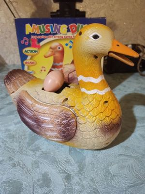 Игрушка утка, которая несет яйца на батарейках