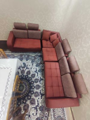 Угловой диван, бардового цвета с 8 подушками.