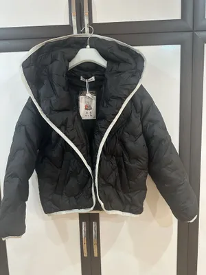 Пуховик черного цвета с большим воротником.