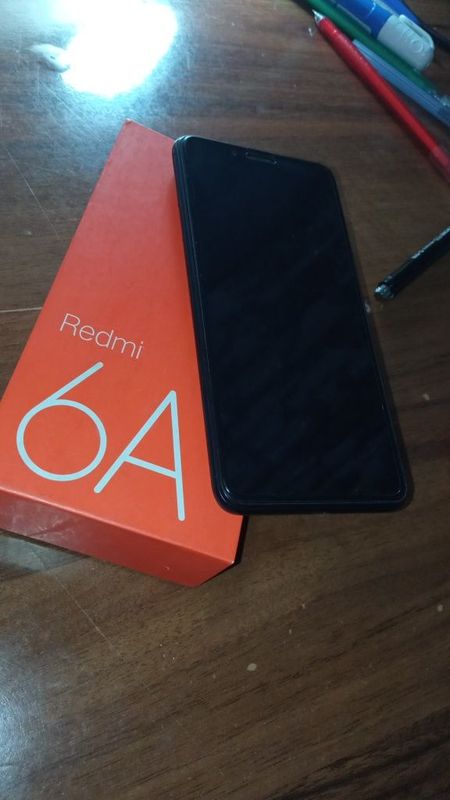 Redmi 6A, qora rangda, ustida zashitasi va chexoli bilan